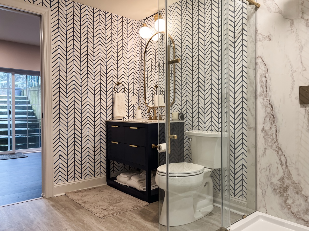Basement bathroom with walk-in shower, patterned tile, and modern vanity. 4