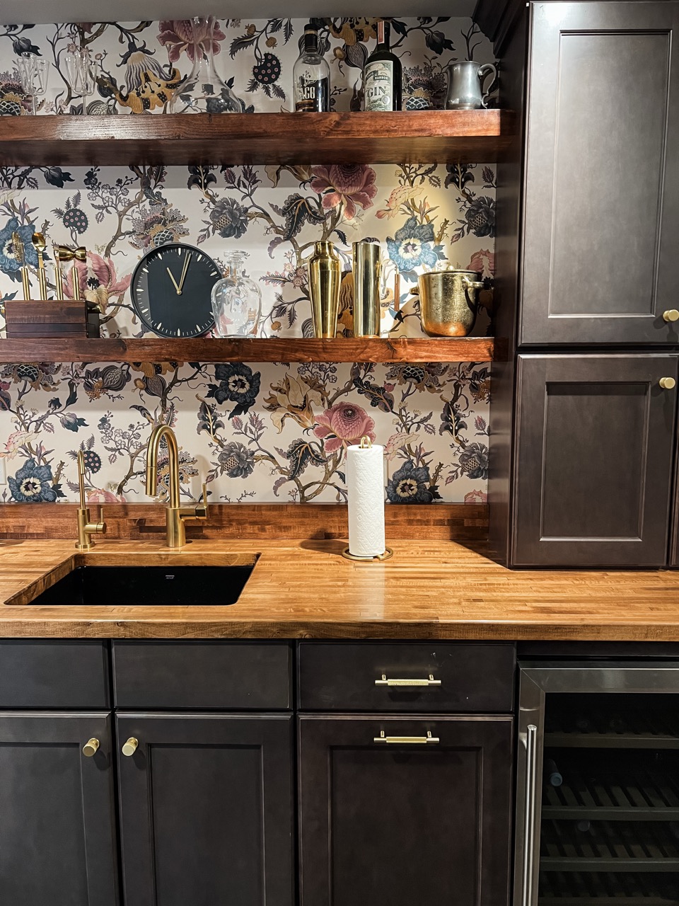Custom basement bar with dark cabinetry, wood countertop, and patterned backsplash 2